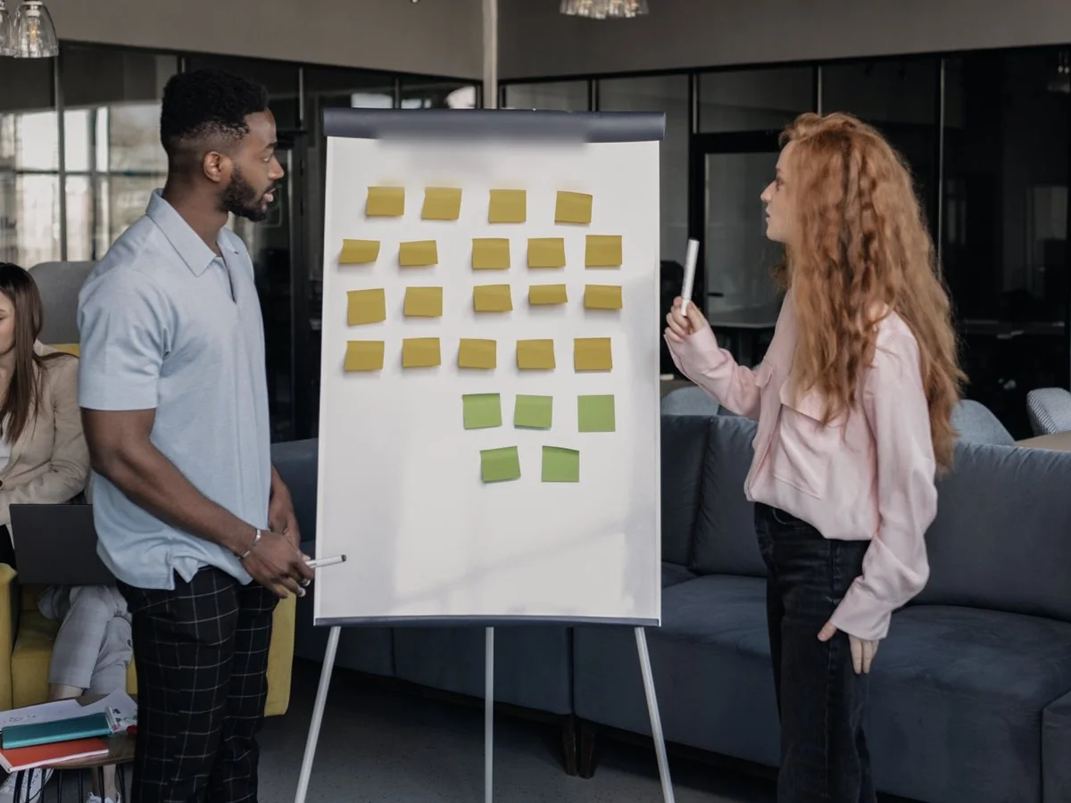 Two colleagues planning work at a flipchart.